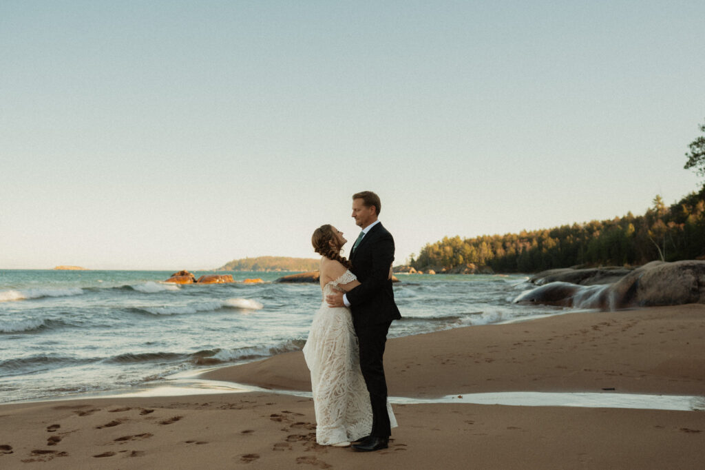 wide shot of wedding couple on lake superior beach