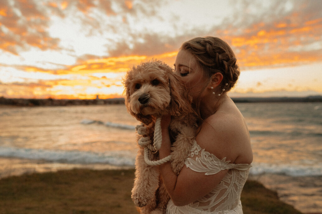 bride with her dog at lake superior sunset wedding